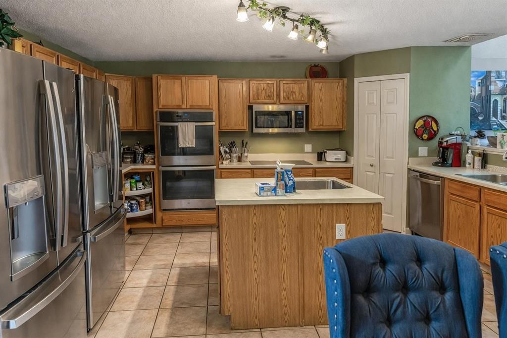 217 Tres Reyes Lane Groveland, FL 34736 - Photo 5 of 20 a kitchen with stainless steel appliances granite countertop a refrigerator stove microwave and sink