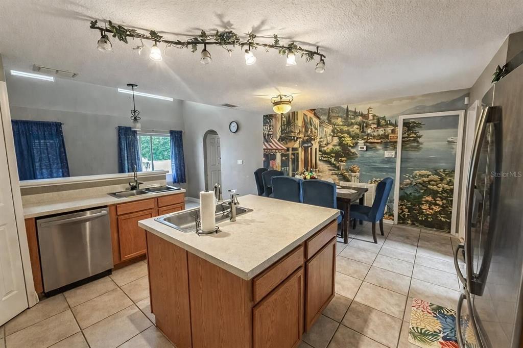217 Tres Reyes Lane Groveland, FL 34736 - Photo 6 of 20 a kitchen with a sink a stove and chairs