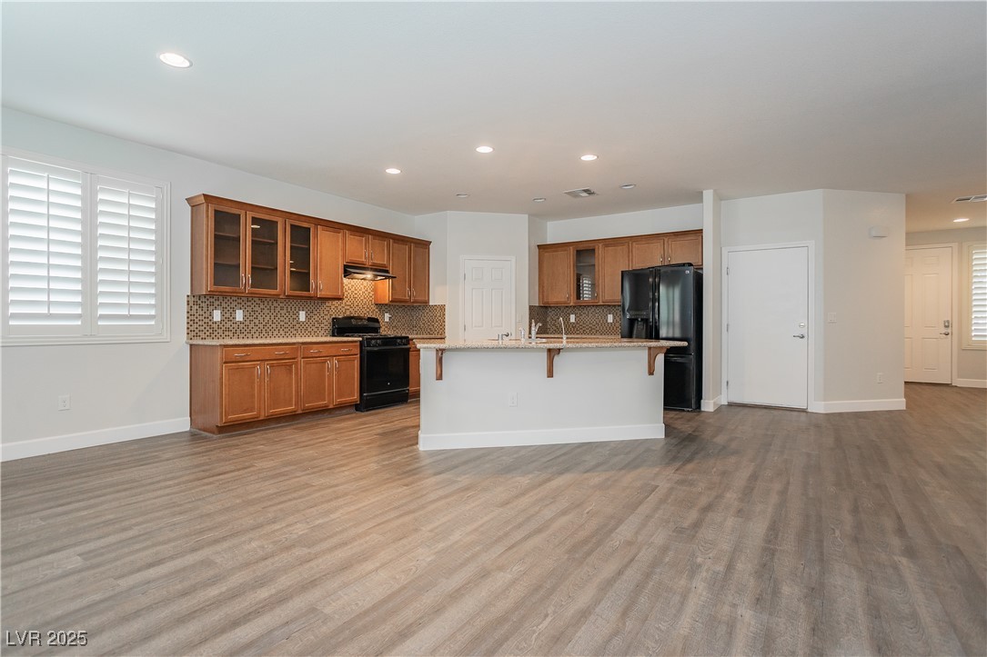 971 Huntington Cove Parkway Las Vegas, NV 89178 - Photo 17 of 55 Kitchen with brown cabinets, light wood finished floors, tasteful backsplash, and recessed lighting