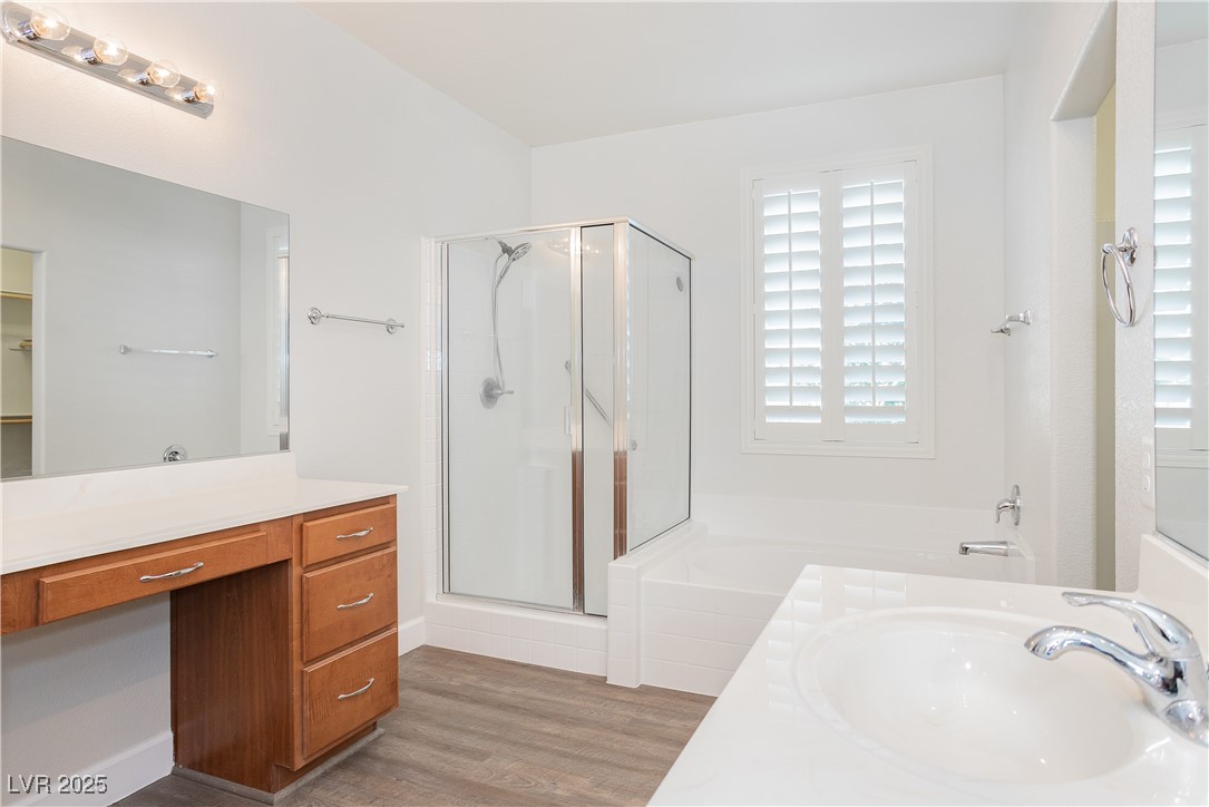 971 Huntington Cove Parkway Las Vegas, NV 89178 - Photo 44 of 55 Bathroom featuring a shower stall, vanity, wood finished floors, and a garden tub