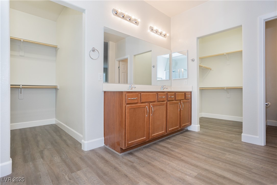 971 Huntington Cove Parkway Las Vegas, NV 89178 - Photo 47 of 55 Bathroom featuring wood finished floors, double vanity, and a spacious closet