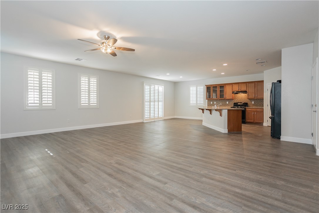 971 Huntington Cove Parkway Las Vegas, NV 89178 - Photo 10 of 55 Unfurnished living room with a ceiling fan, plenty of natural light, recessed lighting, and dark wood-type flooring