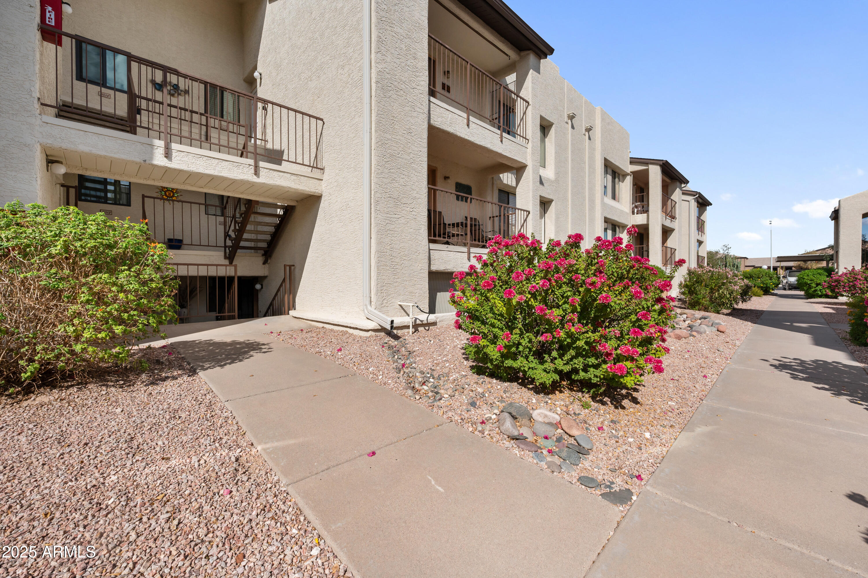 5518 East Lindstrom Lane, Unit 1011 Mesa, AZ 85215 - Photo 31 of 32 a front view of a building with flowers