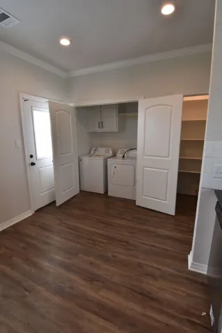a view of a room with wooden floor washer and dryer