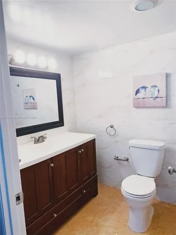 a bathroom with a toilet a sink and vanity