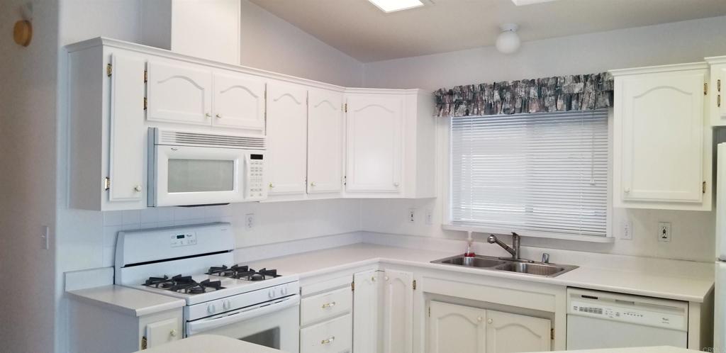 165 Roadrunner Lane Oceanside, CA 92057 - Photo 7 of 20 a kitchen with white cabinets sink and window