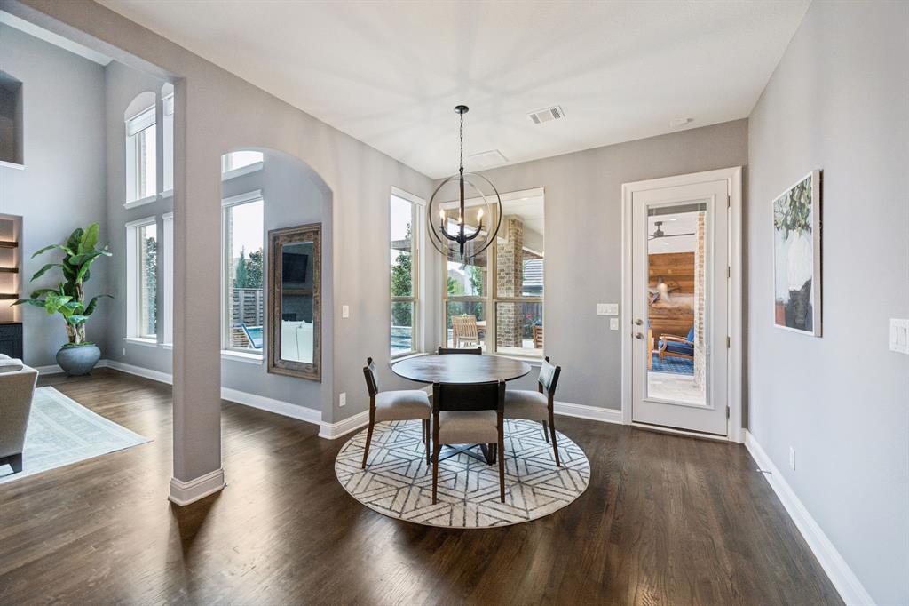 7121 Calypso Lane Frisco, TX 75036 - Photo 11 of 40 a dining room with wooden floor a chandelier a glass table and chairs