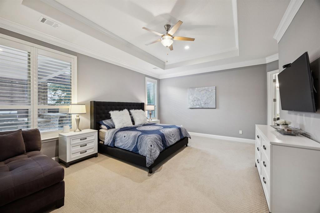 7121 Calypso Lane Frisco, TX 75036 - Photo 17 of 40 a spacious bedroom with a bed and a flat screen tv