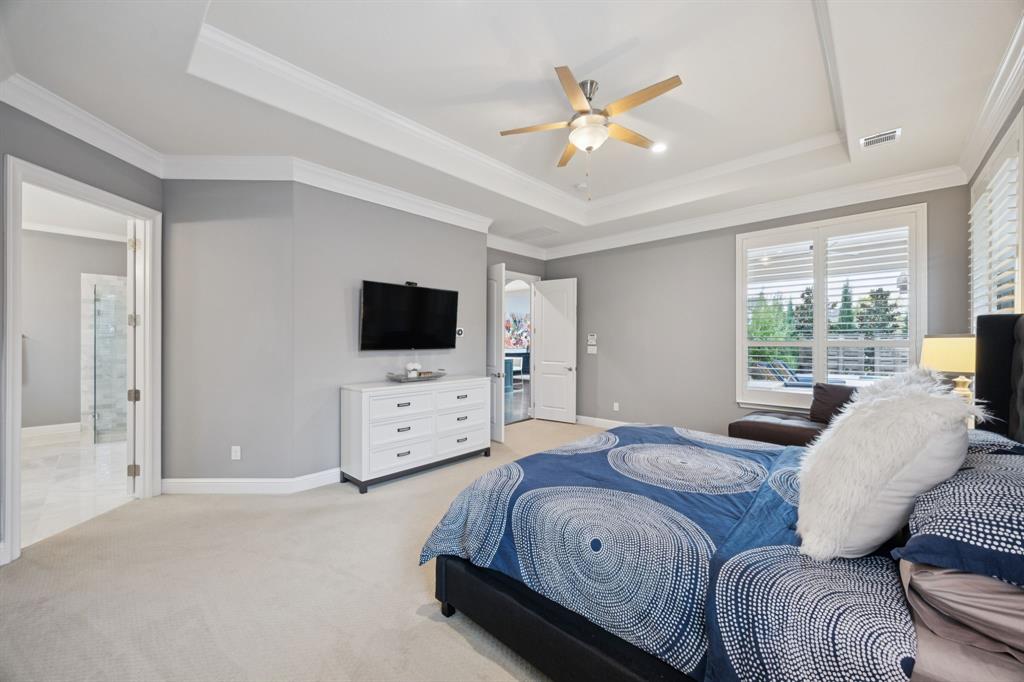 7121 Calypso Lane Frisco, TX 75036 - Photo 18 of 40 a spacious bedroom with a bed and a flat screen tv