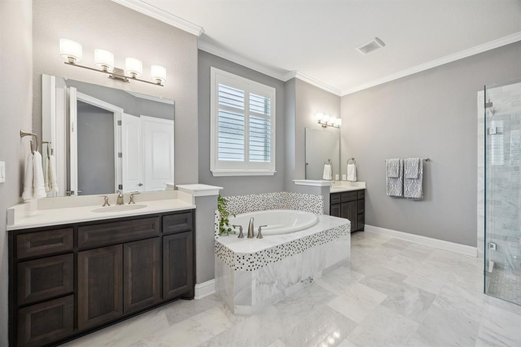 7121 Calypso Lane Frisco, TX 75036 - Photo 19 of 40 a spacious bathroom with a tub double sink and mirror