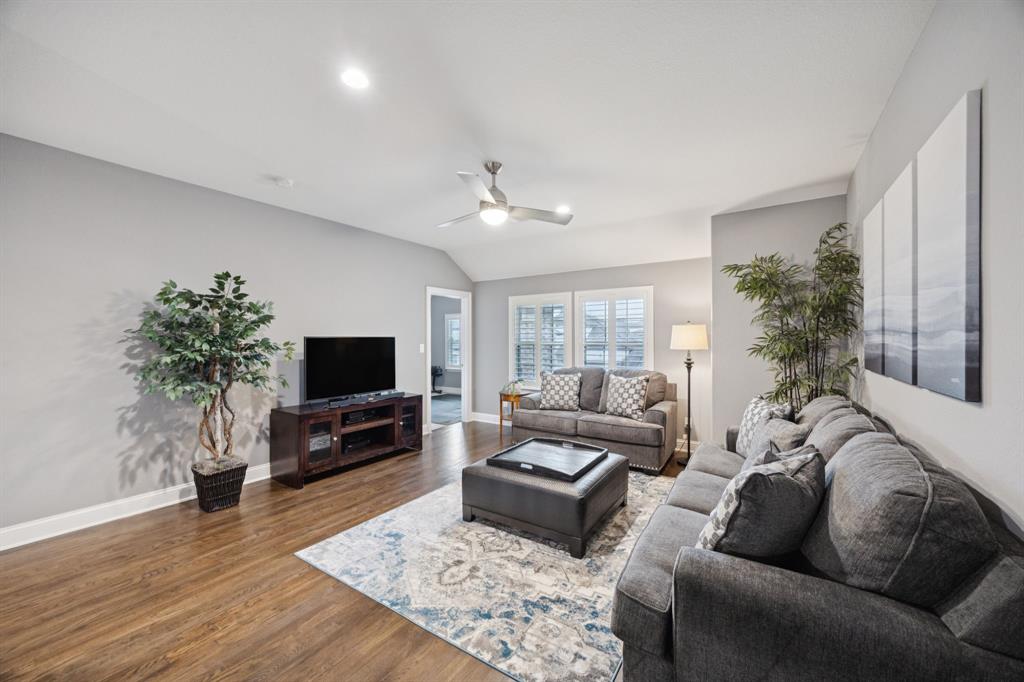 7121 Calypso Lane Frisco, TX 75036 - Photo 26 of 40 a living room with furniture flat screen tv and a fireplace