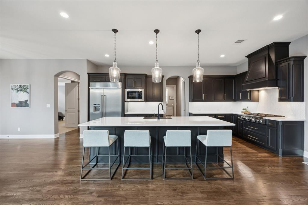 7121 Calypso Lane Frisco, TX 75036 - Photo 8 of 40 a large kitchen with a table and chairs