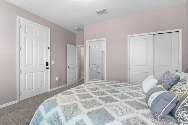 a bedroom with a large bed and a closet