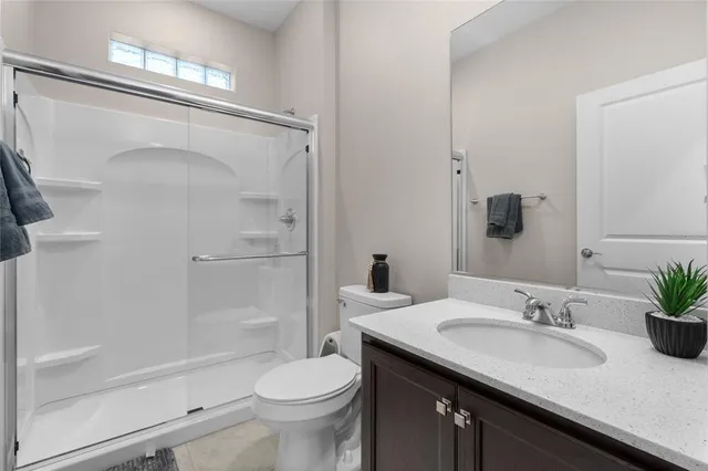 a bathroom with a granite countertop sink a toilet and shower