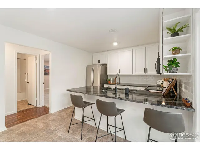 a kitchen with stainless steel appliances kitchen island granite countertop a sink and a refrigerator
