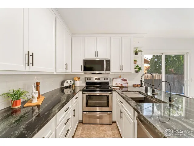 a kitchen with granite countertop a stove and a sink