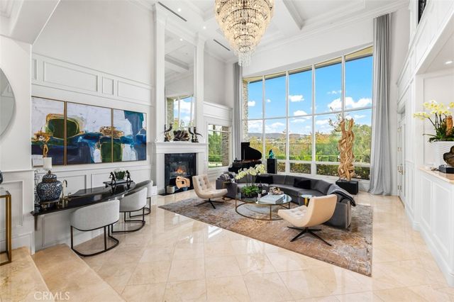 a living room with fireplace furniture and a large window
