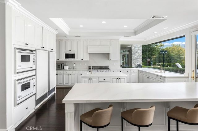 a kitchen with kitchen island white cabinets and refrigerator