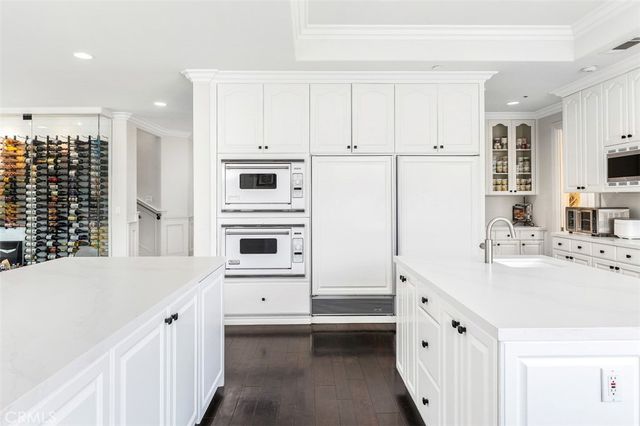 a kitchen with stainless steel appliances a table chairs sink and cabinets
