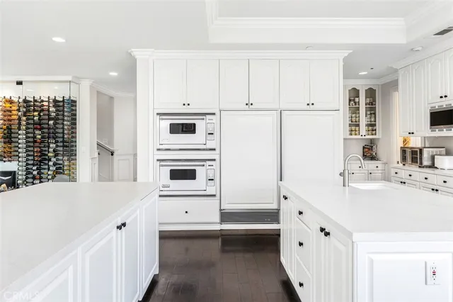a kitchen with kitchen island white cabinets and refrigerator