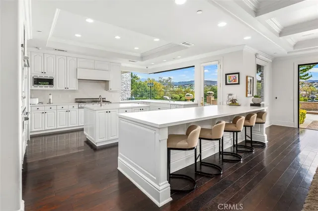 a kitchen with stainless steel appliances a table chairs sink and cabinets