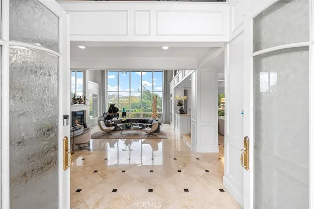a living room with furniture a flat screen tv and a floor to ceiling window