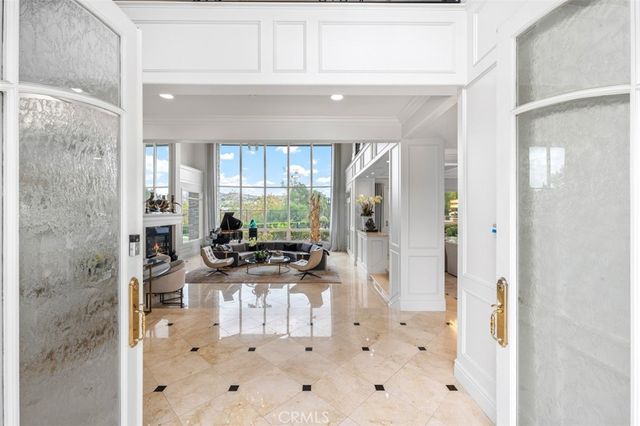 a living room with furniture a flat screen tv and a floor to ceiling window