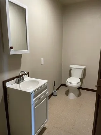 a bathroom with a sink toilet and a mirror