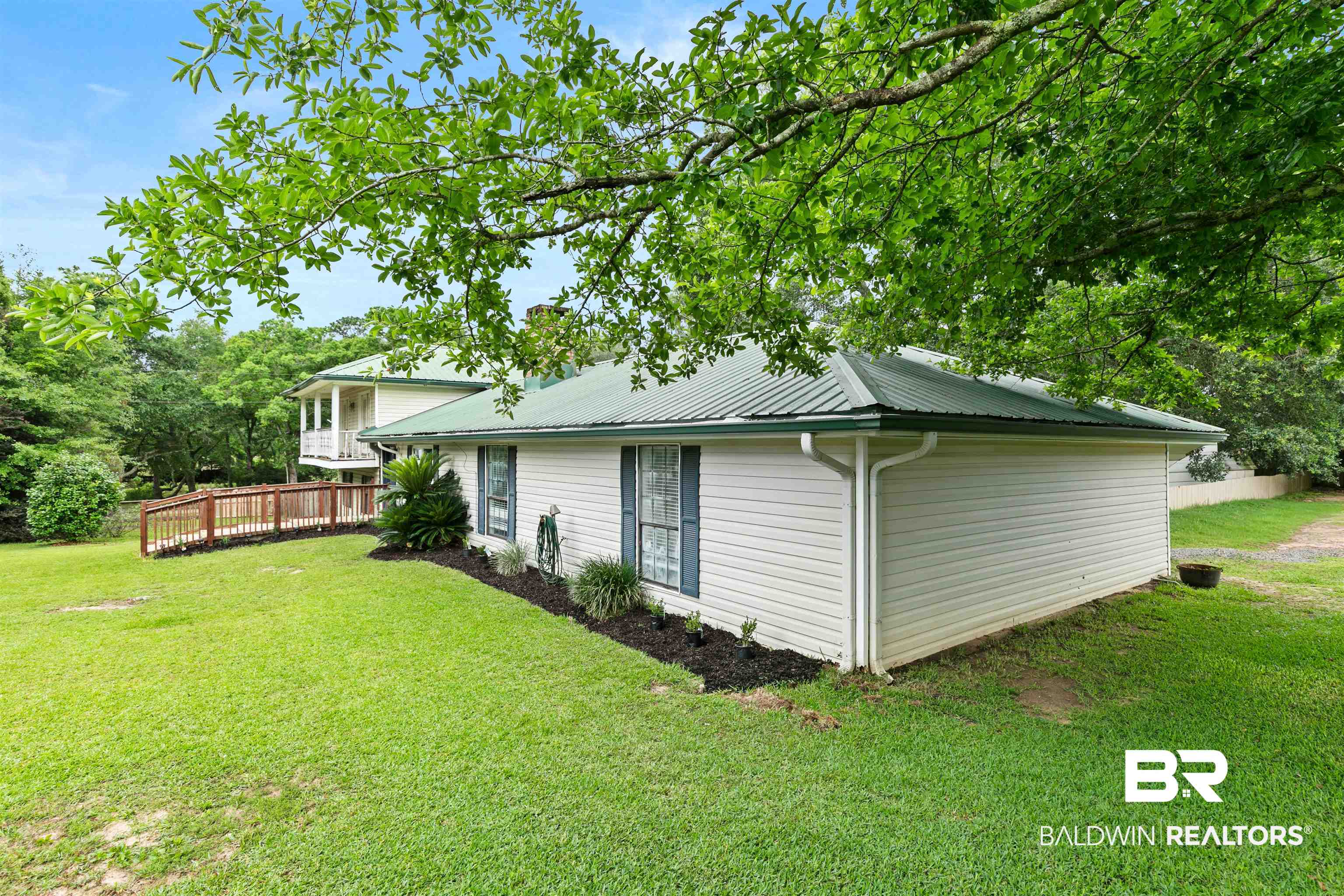 10420 Johnson Road South Mobile, AL 36695 - Photo 10 of 75 White siding exterior with a green metal roof