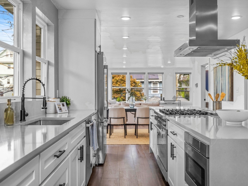 a kitchen with stainless steel appliances granite countertop a sink stove and cabinets