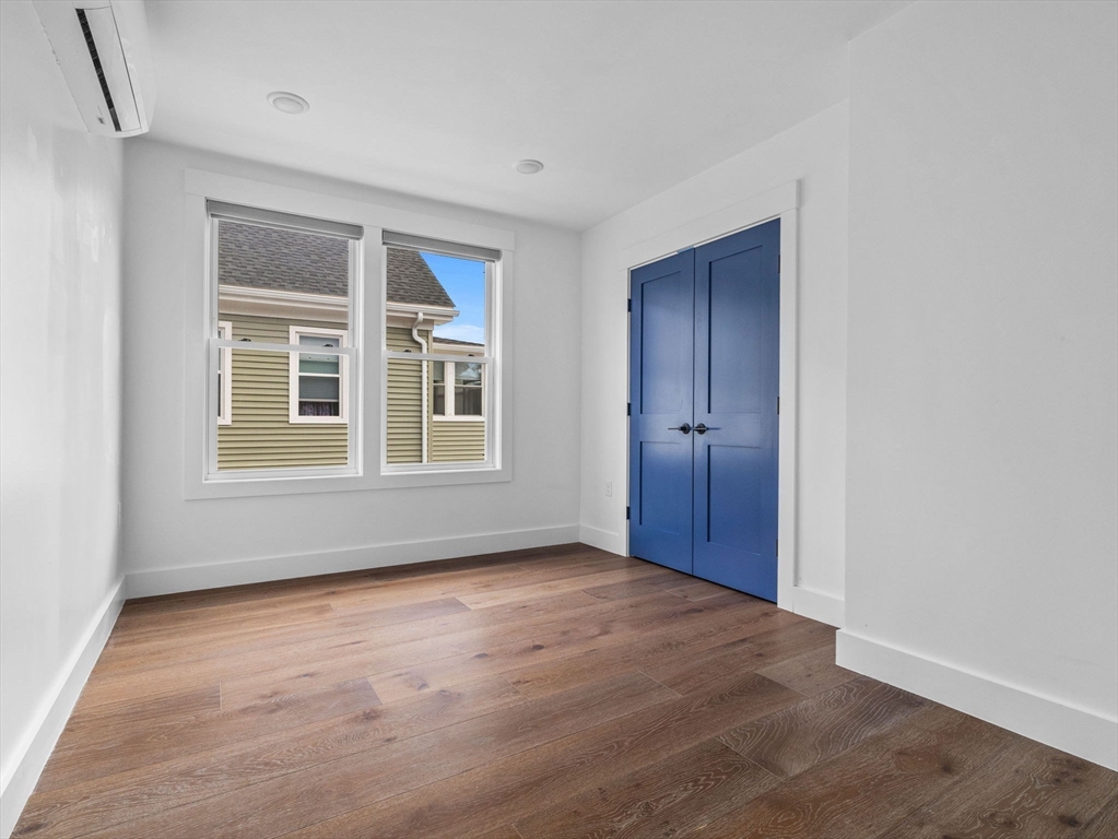 62 Governor Winthrop Road, Unit 2 Somerville, MA 02145 - Photo 19 of 32 a view of an empty room with a window and wooden floor