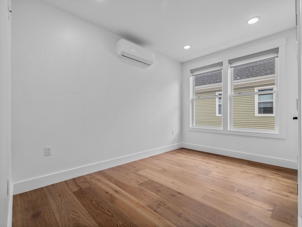 62 Governor Winthrop Road, Unit 2 Somerville, MA 02145 - Photo 20 of 32 an empty room with wooden floor and windows