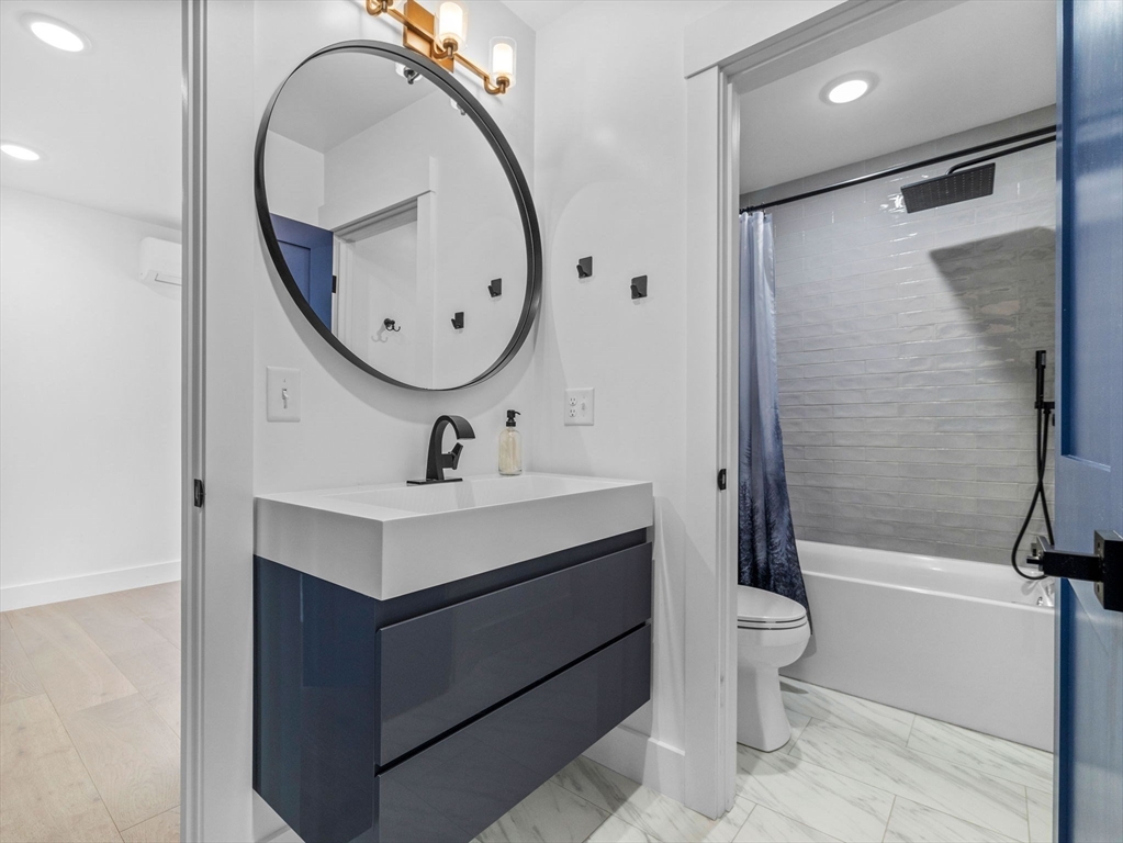 62 Governor Winthrop Road, Unit 2 Somerville, MA 02145 - Photo 21 of 32 a bathroom with a sink mirror bathtub and toilet