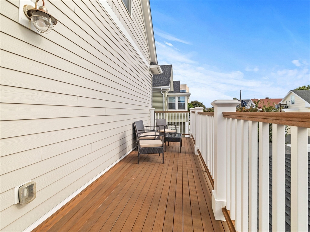 62 Governor Winthrop Road, Unit 2 Somerville, MA 02145 - Photo 23 of 32 a view of balcony with wooden floor and fence and city view