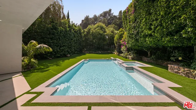 a view of swimming pool with a garden and deck