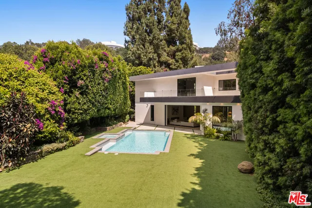 a view of a house with swimming pool and sitting area