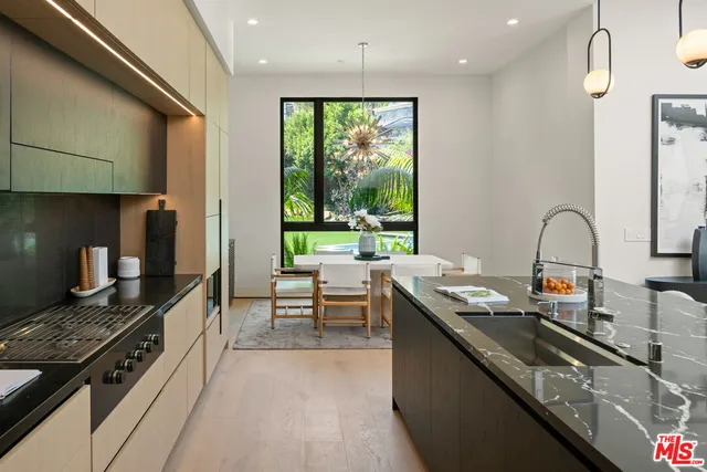 a kitchen with sink a stove and chairs