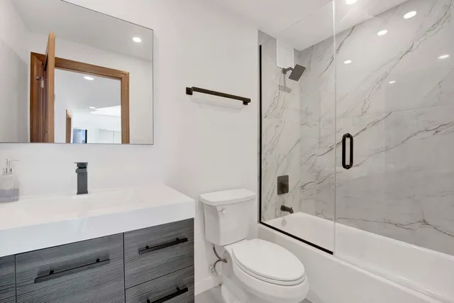 a bathroom with a sink a toilet and shower