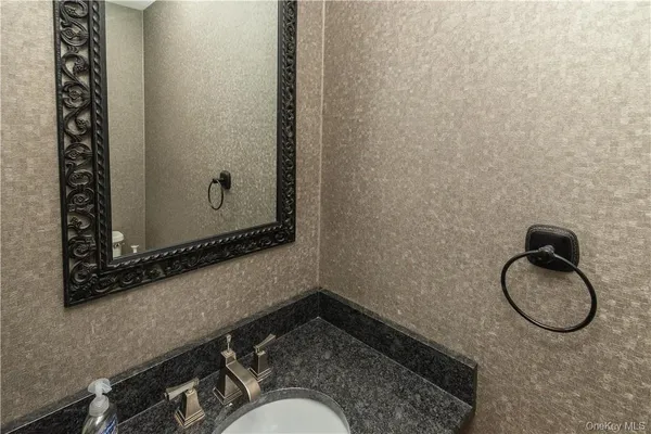 a bathroom with a granite countertop sink and mirror