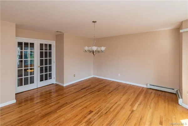 a view of a room with wooden floor and a ceiling fan