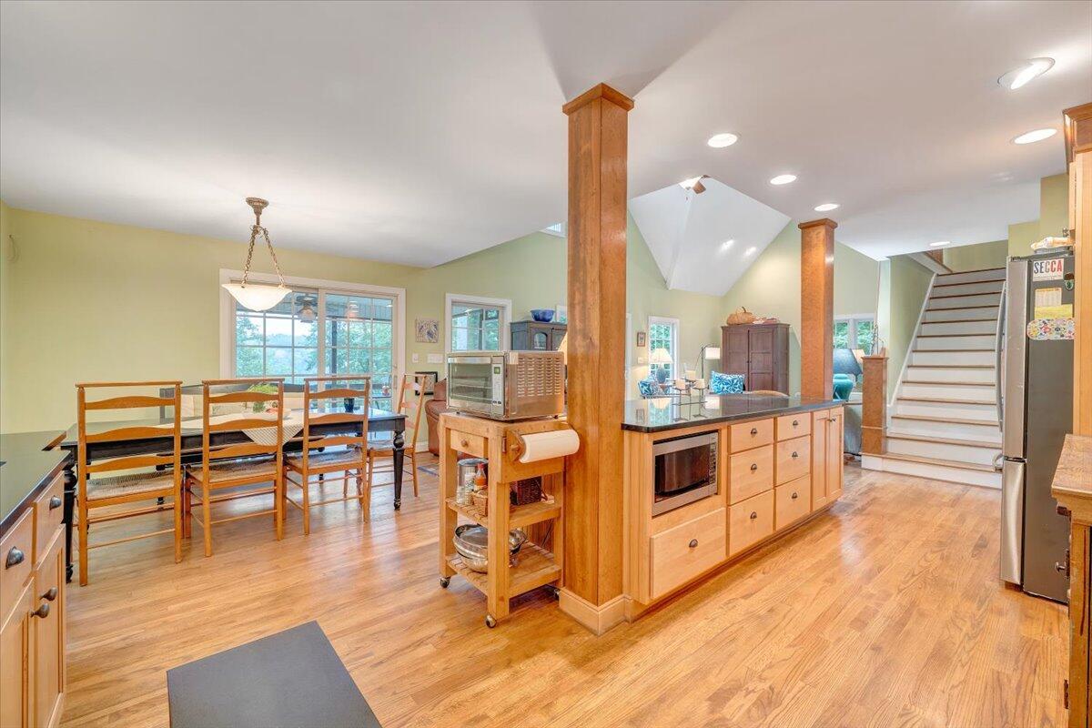 932 Clear Pointe Run Lynch Station, VA 24571 - Photo 57 of 154 a kitchen with stainless steel appliances granite countertop a stove top oven a sink a dining table and chairs with wooden floor