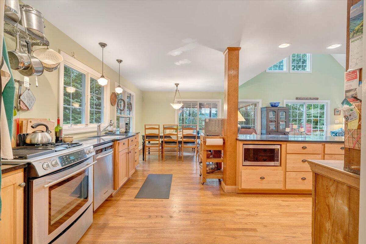 932 Clear Pointe Run Lynch Station, VA 24571 - Photo 58 of 154 a kitchen with stainless steel appliances kitchen island granite countertop a stove a sink and a microwave