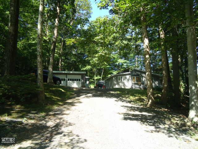 110 Chambers Road Danbury, CT 06811 - Photo 1 of 1 a view of a wooden house next to a yard with large trees