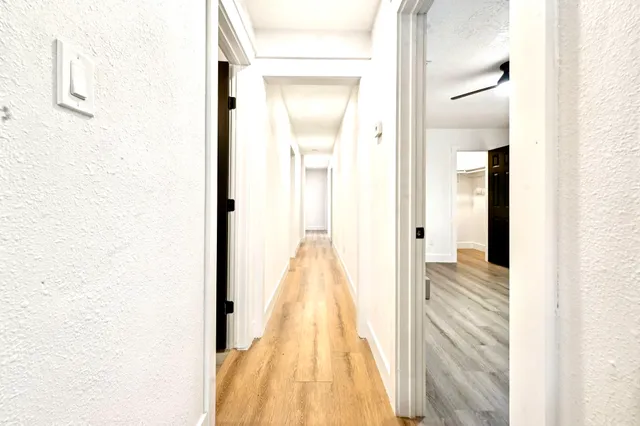 a view of an empty room with wooden floor