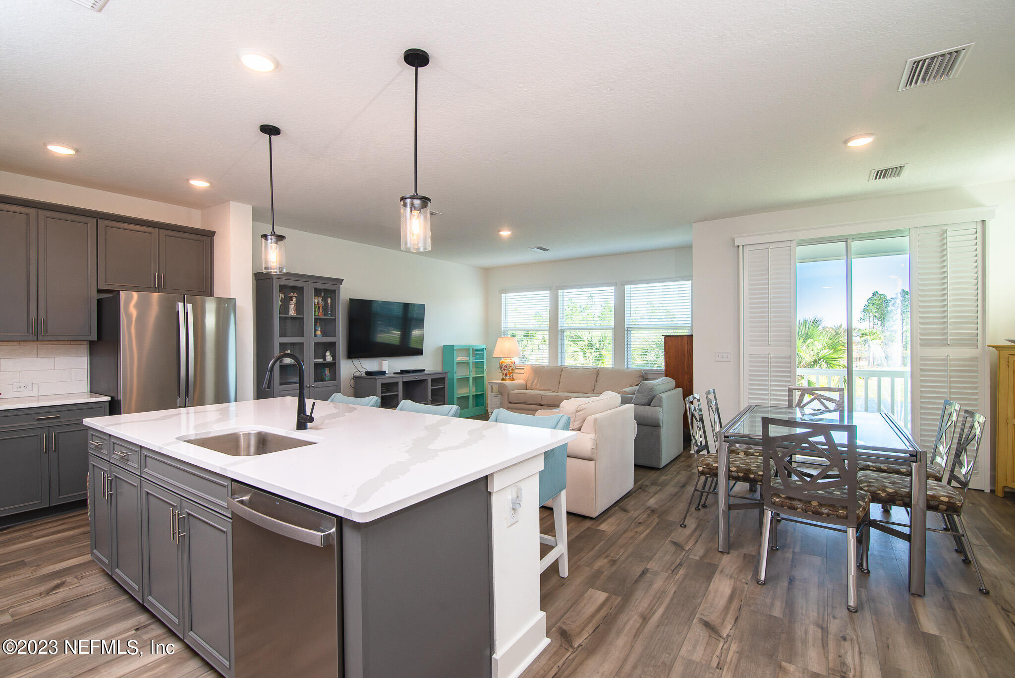 9868 Element Road Jacksonville, FL 32256 - Photo 11 of 36 a large kitchen with kitchen island a island a sink a counter space appliances and living room view