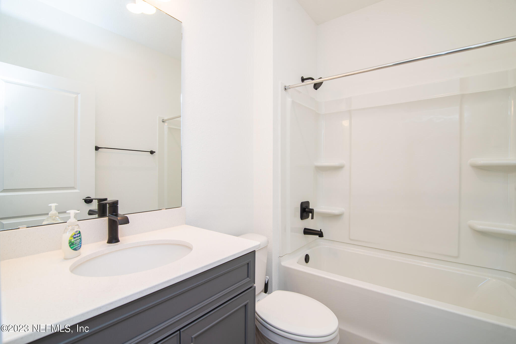 9868 Element Road Jacksonville, FL 32256 - Photo 23 of 36 a bathroom with a granite countertop sink toilet a shower and a bathtub