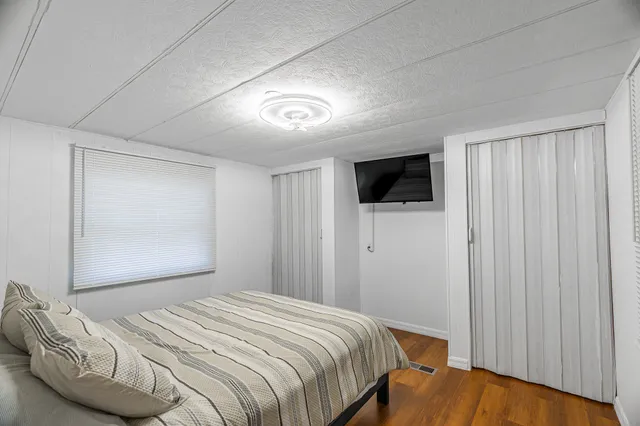 a bedroom with a bed and a painting on the wall