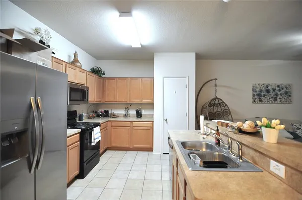 a kitchen with stainless steel appliances granite countertop a sink refrigerator and microwave