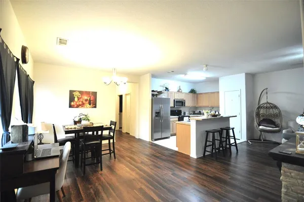 a living room with stainless steel appliances kitchen island granite countertop furniture and wooden floor