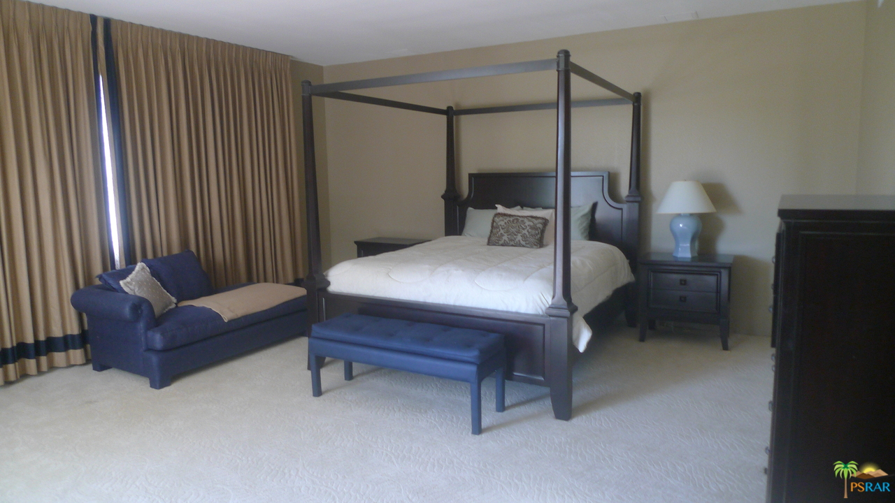 812 Inverness Drive Rancho Mirage, CA 92270 - Photo 17 of 28 a bedroom with a bed and a chandelier